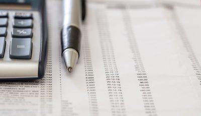 Financial accounting. Pen and calculator on business report, copy space,